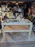 The image depicts a wooden workbench in a garage, with tools, supplies, and a bicycle nearby.  AI-generated content may be incorrect.
